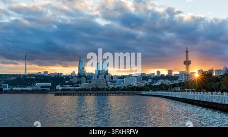 Bakou, Azerbaïdjan – 4 octobre 2026. Vue panoramique sur la skyline de Bakou avec les Tours de Flamme et la côte de la mer Caspienne lors d'un coucher de soleil éclatant. Banque D'Images