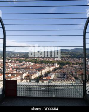 TURIN, ITALIE - 21 OCTOBRE 2026 - Toits de Turin s'étendant vers des collines vertes sous un ciel clair, encadrés par les rambardes des tours Banque D'Images