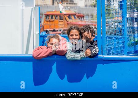 Des enfants égyptiens heureux et joyeux sourient à bord d'une traversière du canal de Suez à Port-Saïd, en Égypte. Banque D'Images