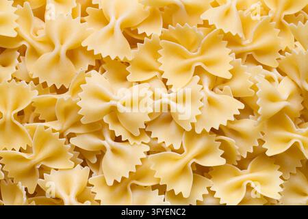 Pâtes crues en forme d'arcs, texture. Beaucoup de pâtes en forme d'arcs Banque D'Images