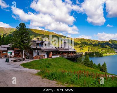 Reichenau, Autriche - 07.07.2016 : Auberge de montagne en bois rustique avec terrasse extérieure nichée dans des collines verdoyantes au bord d'un lac alpin serein Banque D'Images