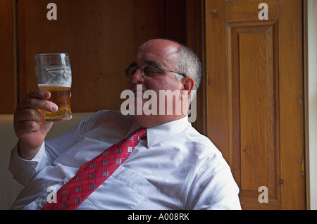 Mature businessman profitant d'une pinte au pub à l'heure du déjeuner Banque D'Images