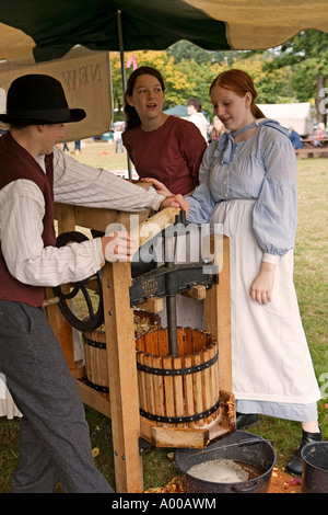 Image d'un groupe d'adolescents vêtus de vêtements pionnier de cidre de pomme à l'aide d'un communiqué de Banque D'Images