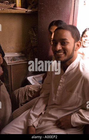 Un employé musulman souriant est assis dans son magasin à Varanasi, Uttar Pradesh, Inde, portant un kurta blanc traditionnel. Banque D'Images