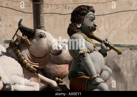 Gros plan d'une divinité masculine hindoue avec une statue de vache dans un temple de rue à Varanasi, Uttar Pradesh, Inde. Banque D'Images