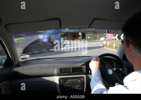 Conduire autour de rond-point avec camion tirant en avant de prendre la voiture de siège arrière de voiture Banque D'Images