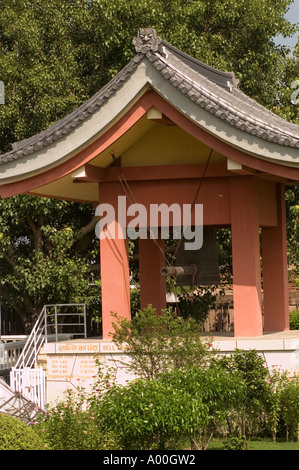Cloche de la paix au temple bouddhiste japonais à Bodhgaya, Bihar, Inde. Architecture japonaise traditionnelle avec une grande cloche en bronze et un percuteur. Banque D'Images