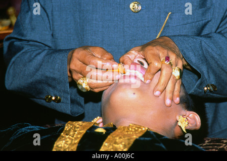Saint homme contrôle de la planéité de la palefreniers dents durant la cérémonie de dépôt des dents à son mariage à Kuta Bali Indonésie Banque D'Images