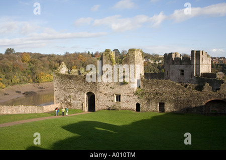 Trois touristes marchant à travers le milieu Bailey avec la rivière Wye derrière le château de Chepstow Wales UK Banque D'Images