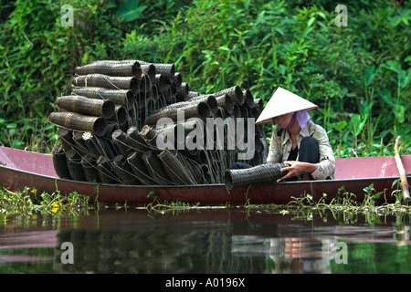 Chapeau conique traditionnel tend pêcheuse panier pièges à poissons sur la rivière Yen menant à la Pagode des parfums près de Hanoi Vietnam Banque D'Images