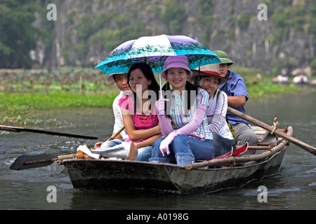 Trois jeunes filles en bateau visiter Tam Coc grottes près de la rivière Ngo Dong Ninh Binh au nord Vietnam Banque D'Images