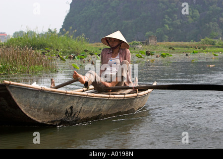 Aviron pied inhabituelle Tam Coc domaine de la rivière Ngo Dong près de Ninh Binh au nord Vietnam Banque D'Images