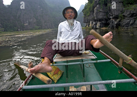 Aviron pied inhabituelle Tam Coc domaine de la rivière Ngo Dong près de Ninh Binh au nord Vietnam Banque D'Images