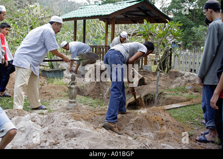 Les musulmans en Malaisie à l'aide d'une pelle pour enterrer les morts. Banque D'Images