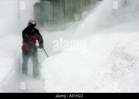 Un homme l'effacement du trottoir avec une souffleuse à neige, pendant une tempête à Boston, Massachusetts Banque D'Images