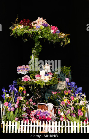 Tea party arrangement de fleurs nature morte avec soucoupes tasses théière gâteau président clôture sur fond noir Banque D'Images