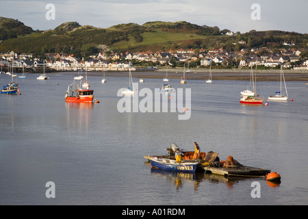 Les pêcheurs de moules sur le déchargement d'une plate-forme de capture avec bateaux amarrés sur l'estuaire de la rivière à marée basse. Le Nord du Pays de Galles Conwy Deganwy UK Banque D'Images