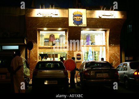 Afficher la fenêtre d'un magasin de parfums Ajmal Colaba avec deux voitures dans la nuit maintenant Bombay Mumbai Maharashtra Inde Banque D'Images