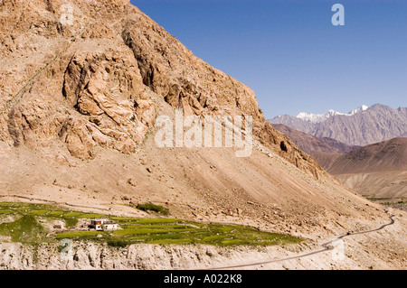 Paysage pittoresque de Nubra Valley Ladakh Inde avec une route sinueuse, des champs verts et des montagnes escarpées sous un ciel bleu clair. Banque D'Images