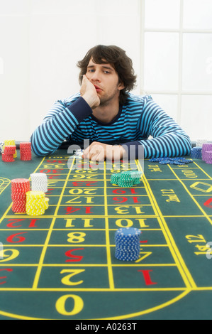 Jeune homme frustré at roulette table Banque D'Images