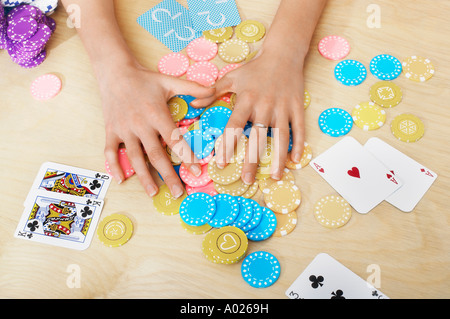 Mains de femme attraper des jetons sur la table, Close up of hands, overhead view Banque D'Images