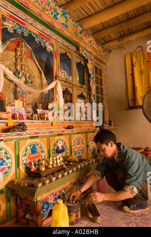 Homme allumant des lampes à beurre dans un temple bouddhiste traditionnel de style Ladakhi dans le village de Basgo, près de Leh, Ladakh, Inde. Banque D'Images