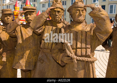 Les amuseurs de rue Strangelings effectuer le déplacement des statues de bronze sur la promenade maritime d'Aberystwyth Wales UK Banque D'Images