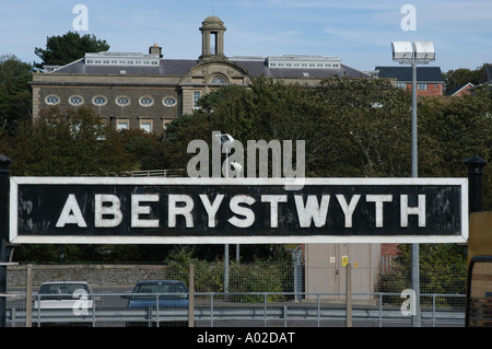 La gare d''aberystwyth signe avec l'Université de Wales School of Art en arrière-plan, Banque D'Images