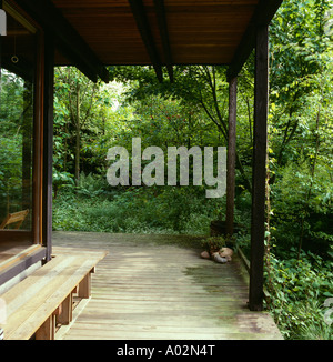 Des bancs en bois et parquet - plancher sur véranda de house situé dans woodland garden Banque D'Images