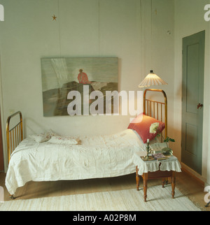 Couvre-lit blanc sur lit simple avec passage de la lumière dans les petits pays scandinaves chambre avec grande photo sur mur Banque D'Images
