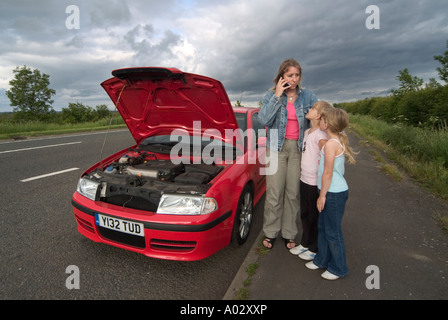 Famille avec une voiture en panne dans une aire de solliciter de l'aide sur un téléphone mobile Banque D'Images