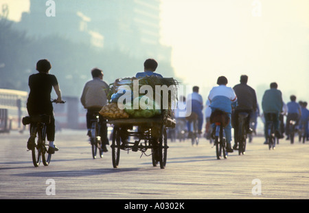 Au début de l'heure de pointe du matin à la place Tiananmen à vélo au travail sur un jour brumeux de smog à Pékin, Chine Banque D'Images