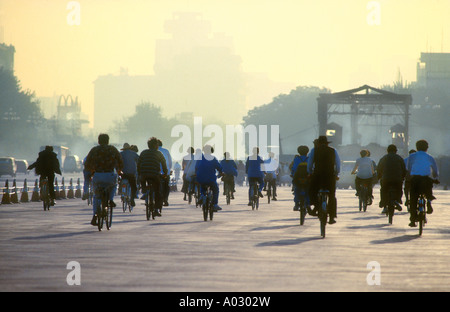 Au début de l'heure de pointe du matin à la place Tiananmen à vélo au travail sur un jour brumeux de smog à Pékin, Chine Banque D'Images