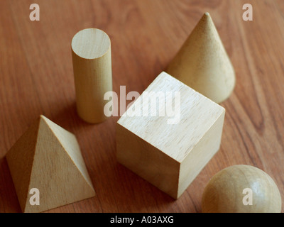 Des blocs de bois dans diverses formes géométriques sur une surface en bois. Banque D'Images