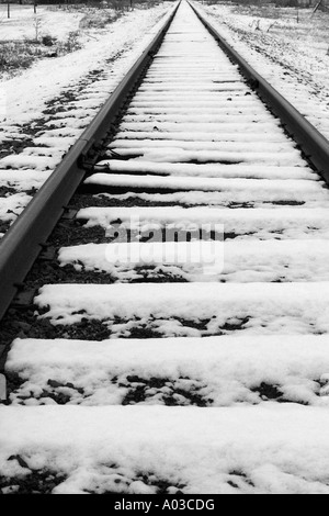 La neige a couvert des voies de chemin de fer qui s'étend au loin dans la distance et sur le dessus du châssis. Banque D'Images