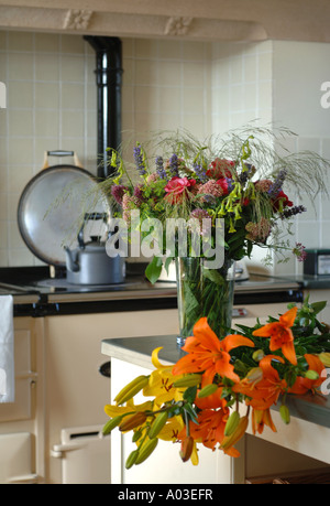 Nénuphars SUR UN PAYS TABLE DE CUISINE AVEC D'AUTRES FLEURS COUPÉES DANS UN VASE UK Banque D'Images