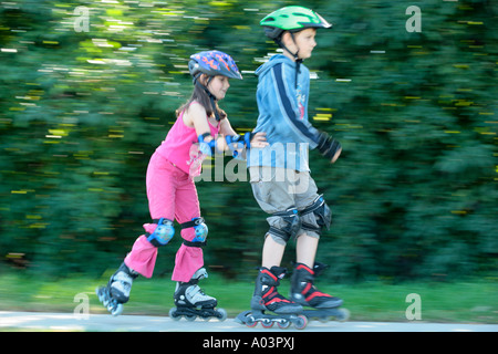 Jeunes patineurs poussant son grand frère Banque D'Images