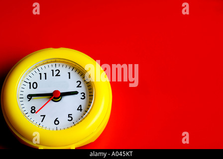 Horloge jaune sur fond rouge Banque D'Images