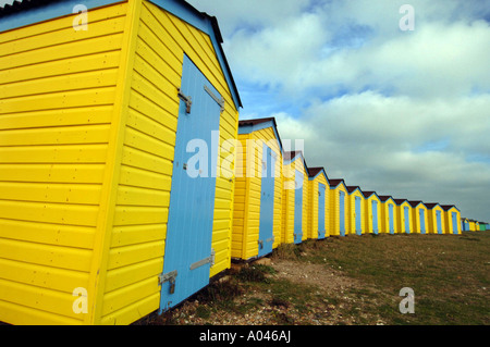 Une rangée de station balnéaire traditionnelle fraîchement peint des cabines de plage sur la berge à Littlehampton, Sussex, England, UK. Banque D'Images