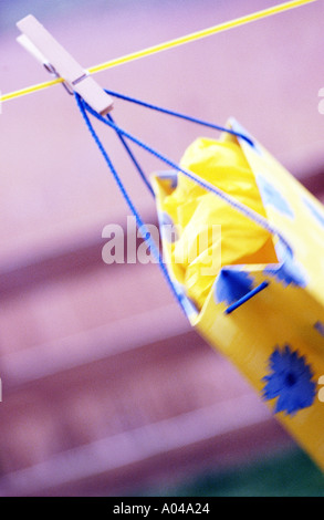 Panier jaune unique rattaché à une corde à linge Banque D'Images