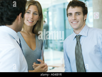 Jeunes cadres parler, man looking at camera Banque D'Images