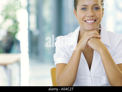 Young avec les mains jointes sous le menton, smiling, portrait Banque D'Images