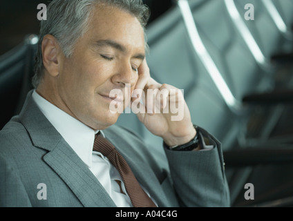 Businessman sleeping in airport lounge Banque D'Images