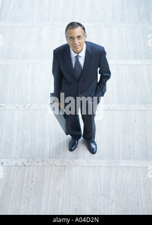 Businessman standing with briefcase, high angle view Banque D'Images