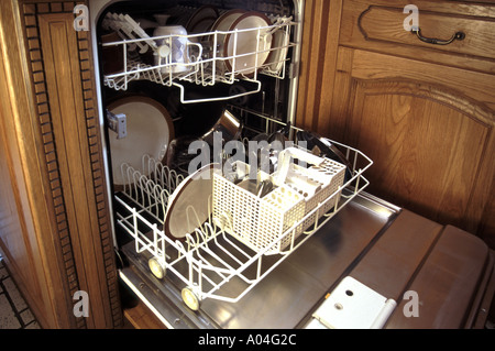 Lave-vaisselle produits blancs électrique cuisine maison lave-linge gros plan vaisselle propre et couverts dans les plateaux vue intérieure avec porte ouverte Angleterre Royaume-Uni Banque D'Images