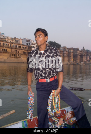 L'Uttar Pradesh VARANASI INDE Novembre Hawker essayant de vendre ses souvenirs pour les visiteurs voyageant sur le fleuve Ganges Banque D'Images