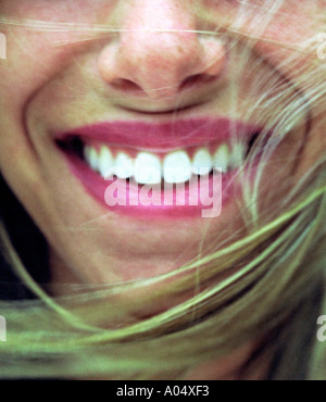 Un close-up of a woman smiling avec le vent et montrant ses dents. Banque D'Images