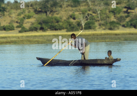 Pêcheur et petit garçon dans un canot creusé dans la bande de Caprivi Chobe à la frontière entre le Botswana et le Zimbabwe Banque D'Images