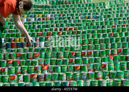 Un réglage avec précaution personne de milliers de boîtes de haricots blancs disposés en spirale énorme. Perth, Australie occidentale Banque D'Images