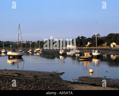 Bateaux amarrés au quai rouge au-delà de la baie de sable à marée basse in early morning light red Wharf Bay Ile d'Anglesey au Pays de Galles UK Banque D'Images